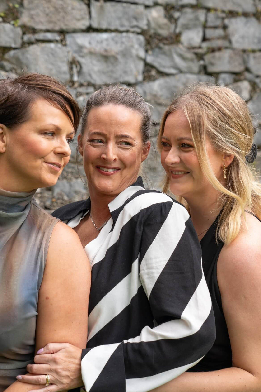 this is the business owners image - three female founders - two sisters and a daughter(niece) they are smiling and on a photo shoot for the rebranding of their candle business - irish hand made candles 